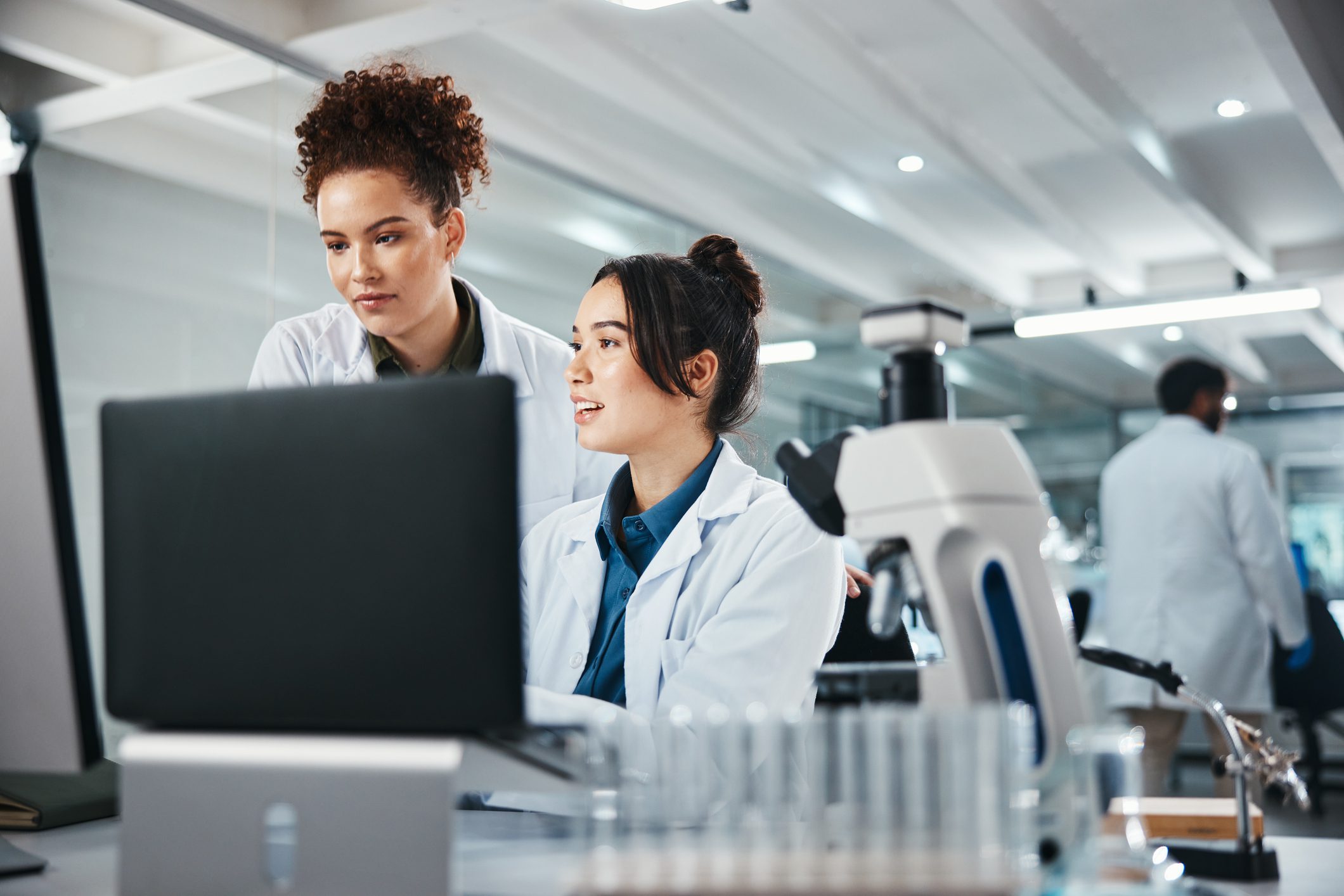 Two scientists reviewing data on computer in lab